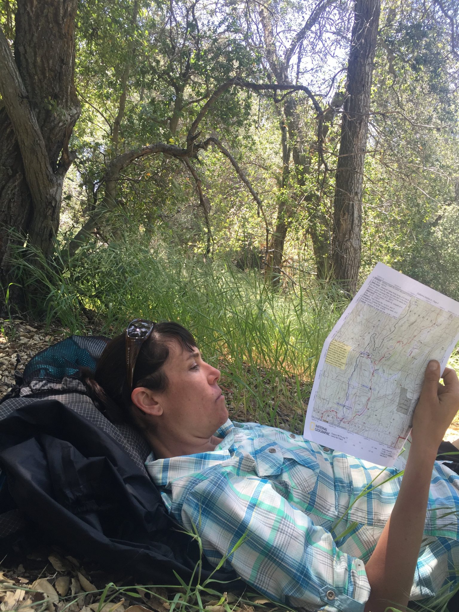 Em studying maps in the shade