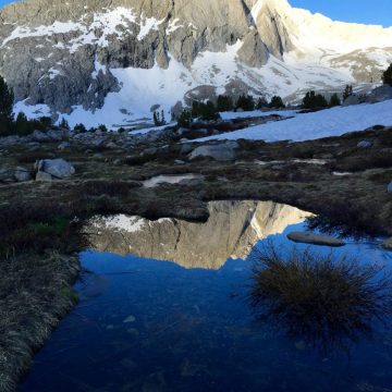 A small tarn perfectly mirroring the mountain above