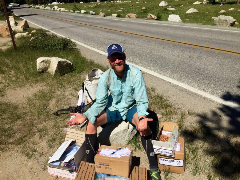 Mountain Man sitting on a pile of care packages