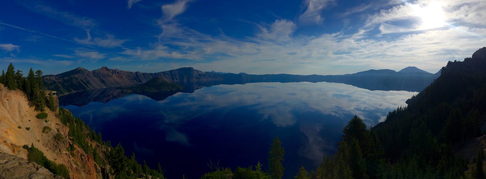 Blue sky reflected against the mirror surface of Crater Lake