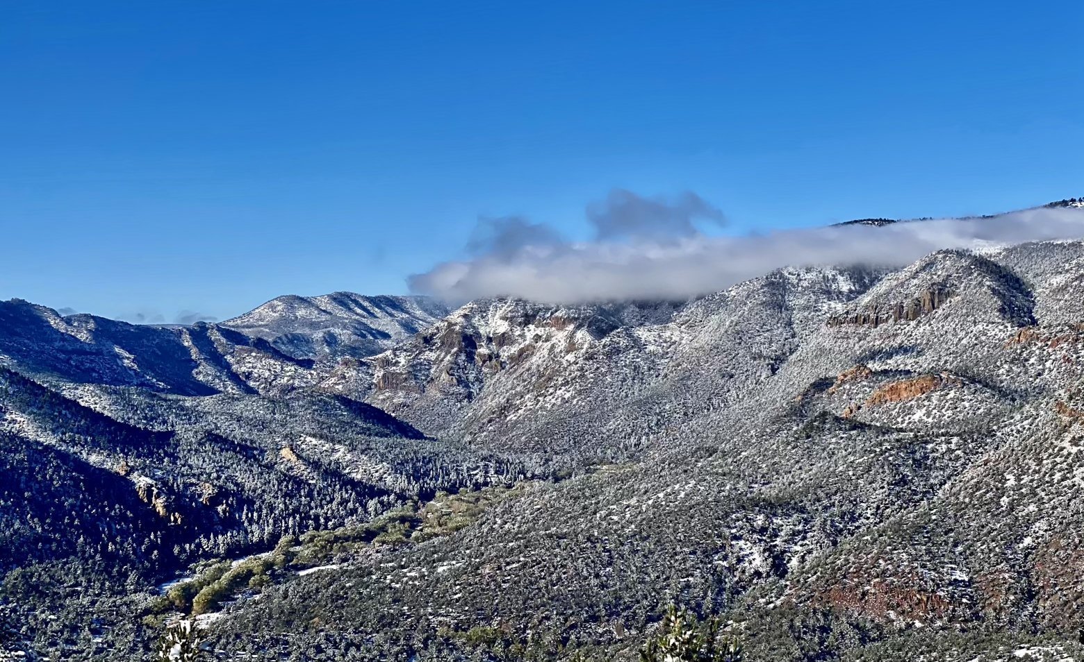 A snow covered and cloud capped canyon